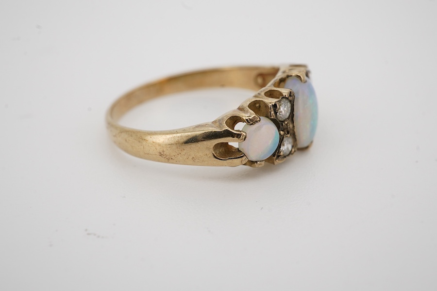 A modern 9ct gold, three stone white opal and four stone diamond set half hoop ring, size N, gross weight 2.4 grams.